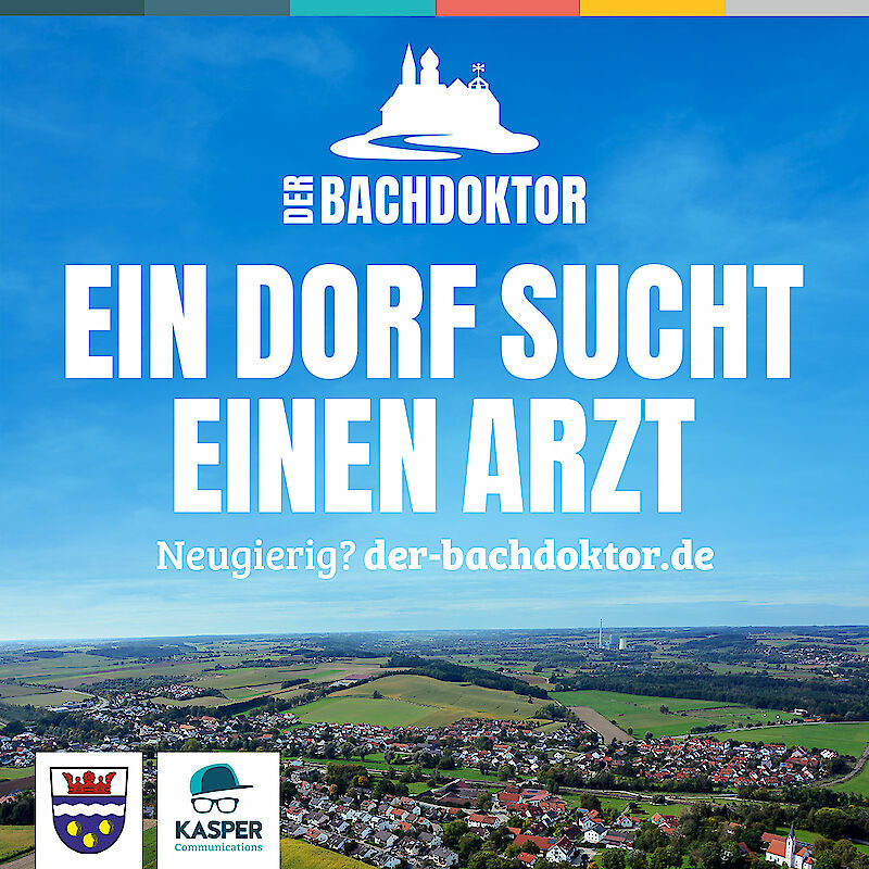 Kampagnenbild „Der Bachdoktor“ mit blauem Himmel und Dorflandschaft. Weißer Text: „Ein Dorf sucht einen Arzt“ und Weblink „der-bachdoktor.de“. Logos der Gemeinde und Kasper Communications unten