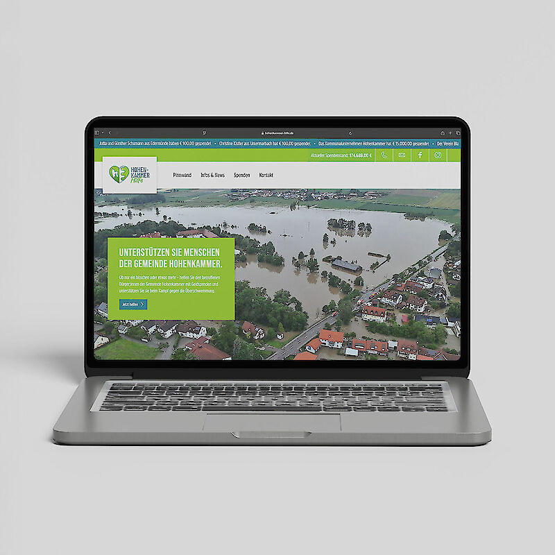 Laptop mit geöffneter Webseite der Spendenaktion „Hohen-Kammer-Hilft“ zur Hochwasserhilfe in der Gemeinde Hohenkammer. Auf dem Bildschirm ist ein Drohnenfoto einer überfluteten Ortschaft zu sehen, mit dem Spendenaufruf „Unterstützen Sie Menschen der Gemeinde Hohenkammer“. Die Website informiert über Schäden, Spendemöglichkeiten und den aktuellen Spendenstand. Ideal für SEO rund um Hochwasserhilfe Bayern, Spendenaktion Hohenkammer, Naturkatastrophenhilfe und regionale Solidarität.