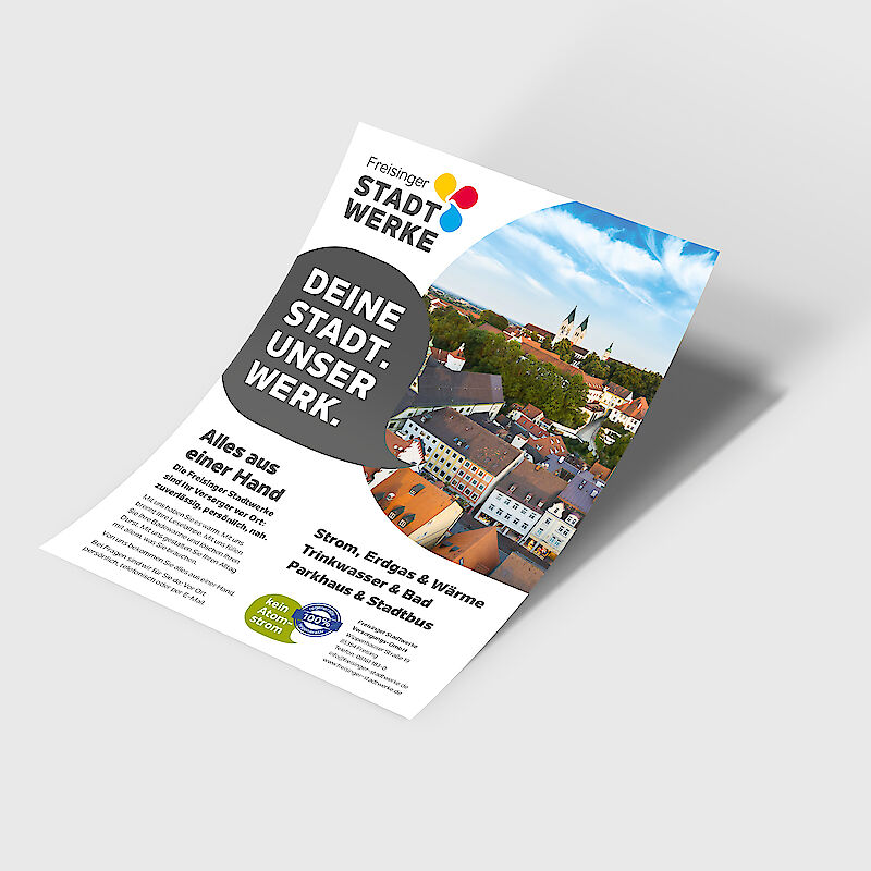 Werbeflyer der Freisinger Stadtwerke mit dem Slogan „DEINE STADT. UNSER WERK.“ vor einem Luftbild von Freising mit dem Dom St. Maria und St. Korbinian. Der Flyer präsentiert die regionalen Dienstleistungen der Stadtwerke Freising: Strom, Erdgas, Fernwärme, Trinkwasser, Schwimmbad, Parkhaus und Stadtbus. Hervorgehoben werden der nachhaltige Anspruch mit „Kein Atomstrom“ und „100 % Ökostrom aus Wasserkraft“ sowie das Motto „Alles aus einer Hand“. Ideal für SEO rund um Energieversorgung, Stadtwerke Freising und regionale Infrastruktur.