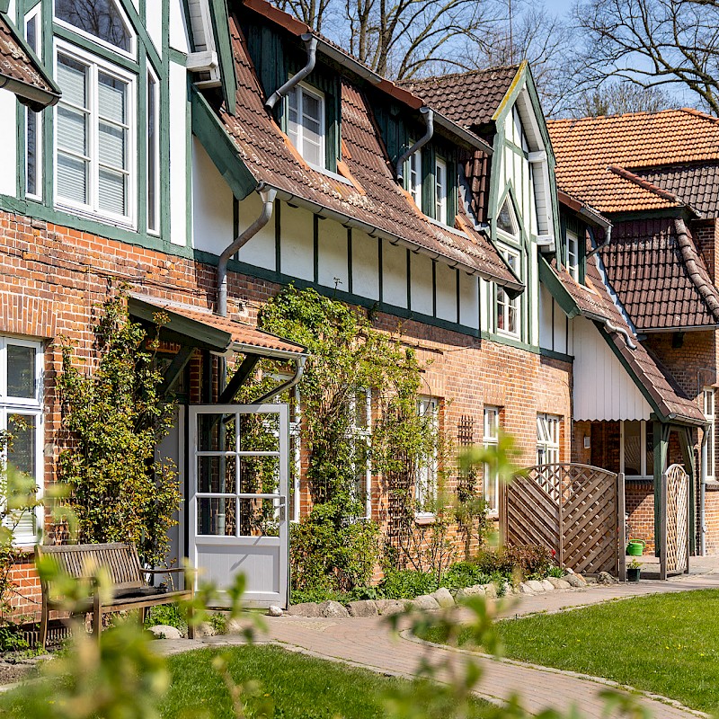 Ein Backsteinhaus in einer Häuserreihe mit einer offenen weißen Haustür.