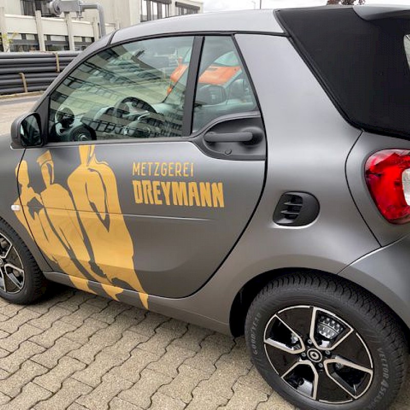Kleines graues Auto mit bedruckter Seite ist im Fokus.