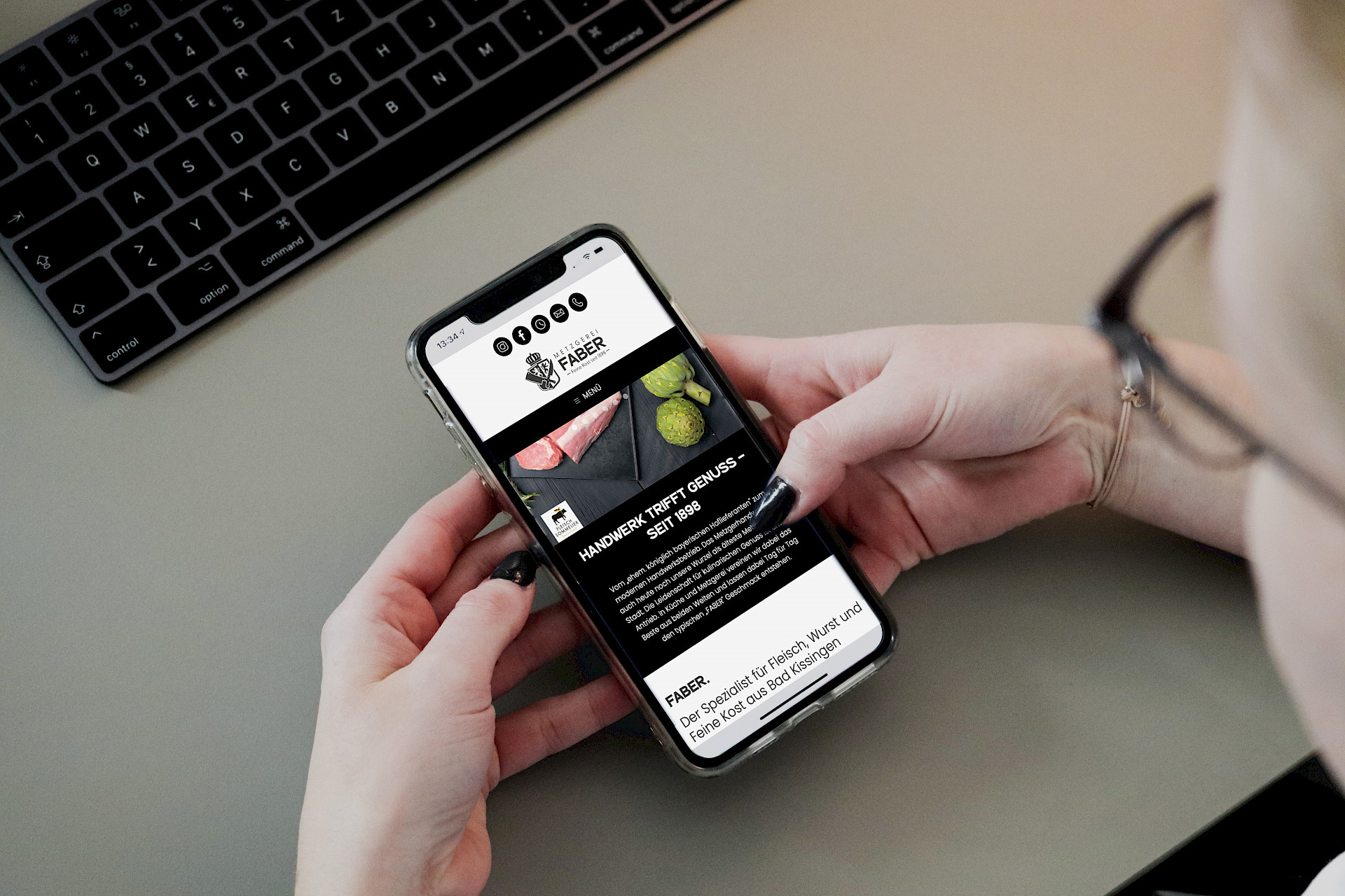 Person die Handy hält mit Website der Metzgerei faber geöffnet.
