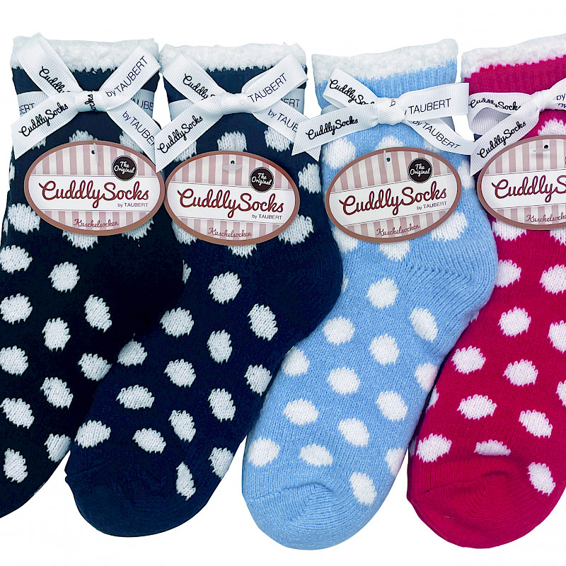 Verschiedenfarbiger gepunktete Socken liegen nebeneinander